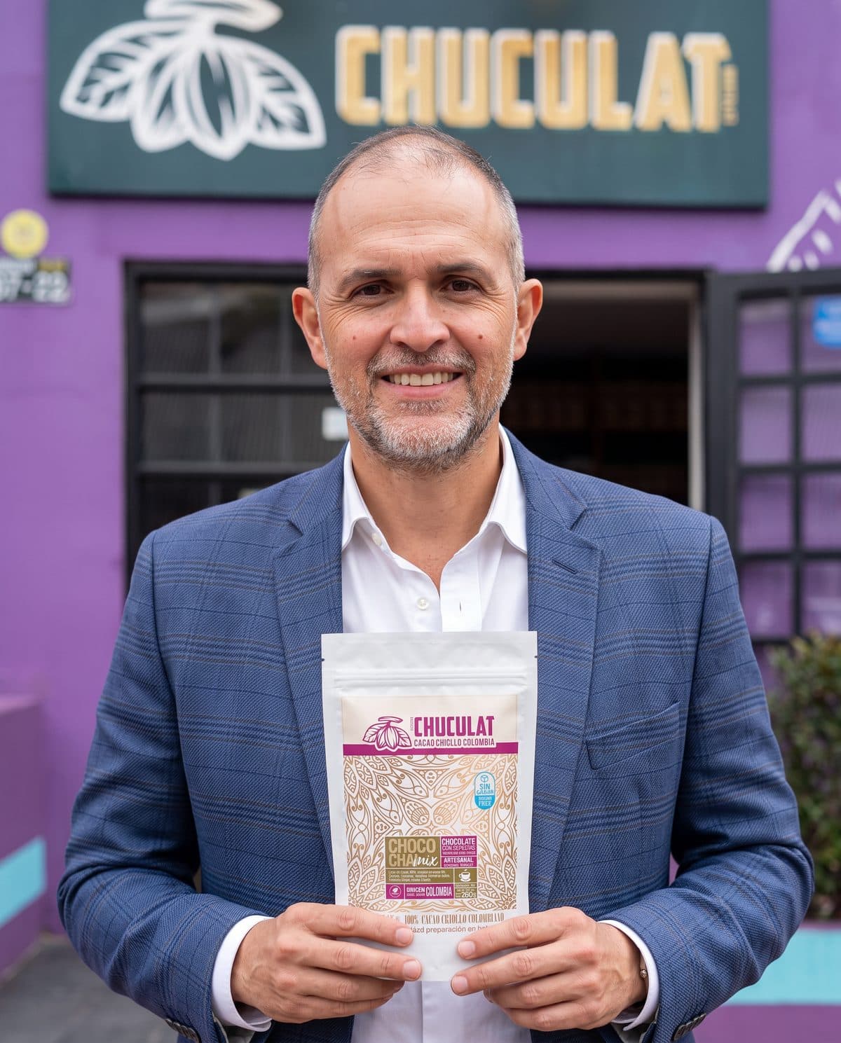 Hernán, fundador de CHUCULAT, frente a la tienda con un producto en las manos